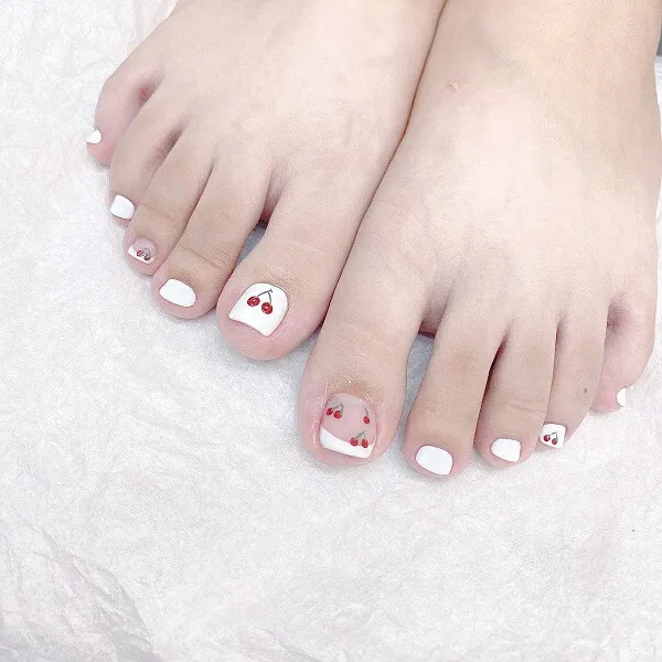 Mẫu nail trắng sang chảnh có hai cặp móng chân với anh đào được vẽ trên chúng