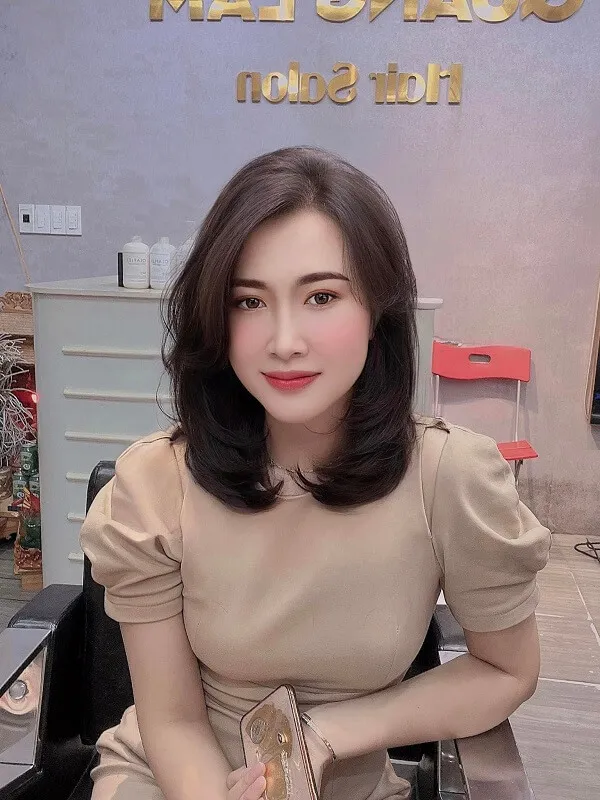 Mẫu tóc bob có một người phụ nữ đang ngồi bàn với chiếc ví
