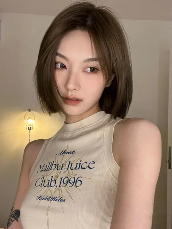Mẫu tóc bob có một người phụ nữ với hình xăm trên cánh tay của cô ấy tạo dáng cho bức ảnh