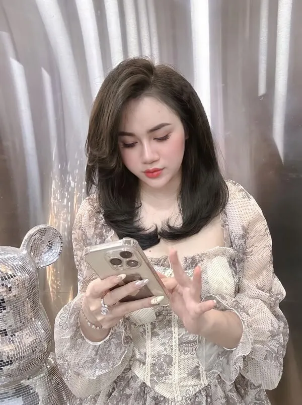 Mẫu tóc bob có một người phụ nữ đang nhìn vào điện thoại di động của cô ấy