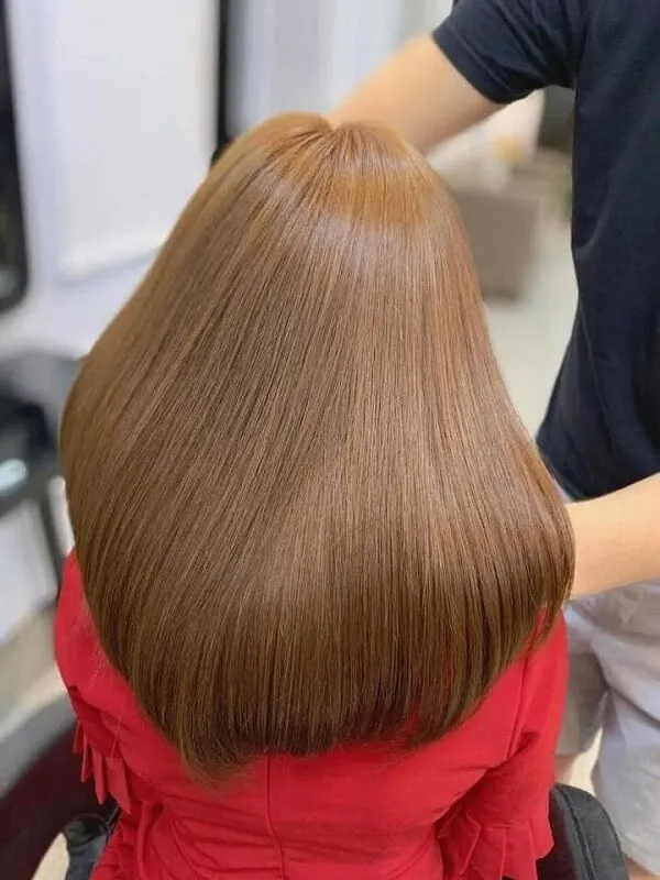 Mẫu tóc đẹp có một người phụ nữ ngồi trên ghế bị cắt
