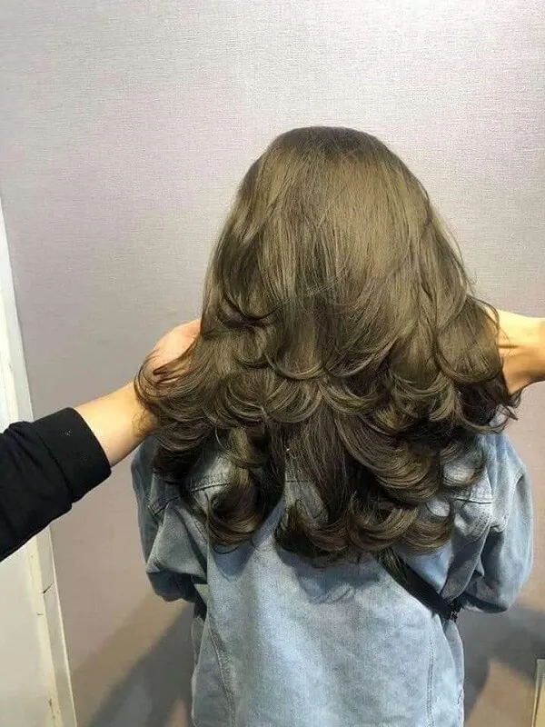 Mẫu tóc nam đẹp có một người phụ nữ đứng trước gương đánh