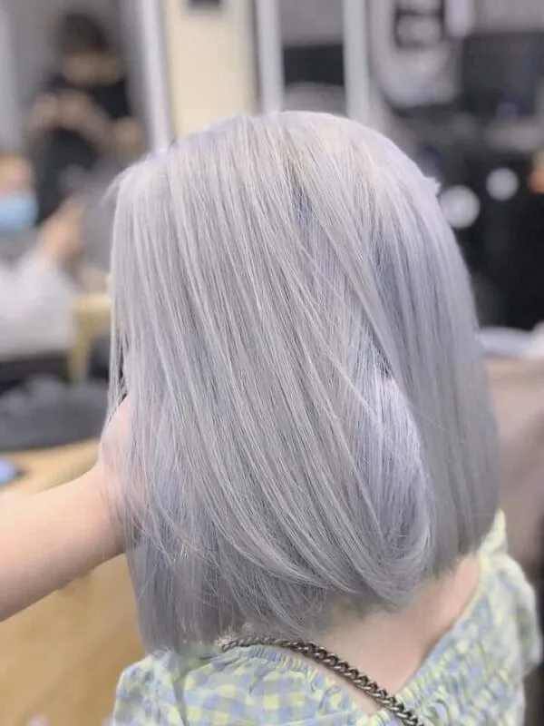 Mẫu tóc nam ngắn đẹp có một người phụ nữ đang làm tại tiệm