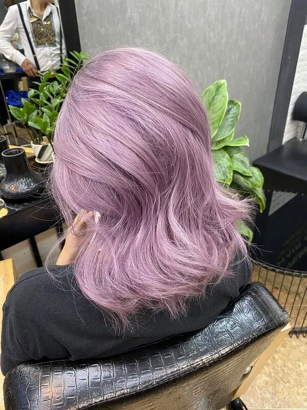 Mẫu tóc đẹp có một người phụ nữ đang ngồi trên ghế với mái màu tím