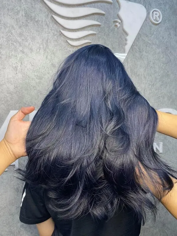 Mẫu tóc đẹp có một người phụ nữ mái đen dài đứng trước tường