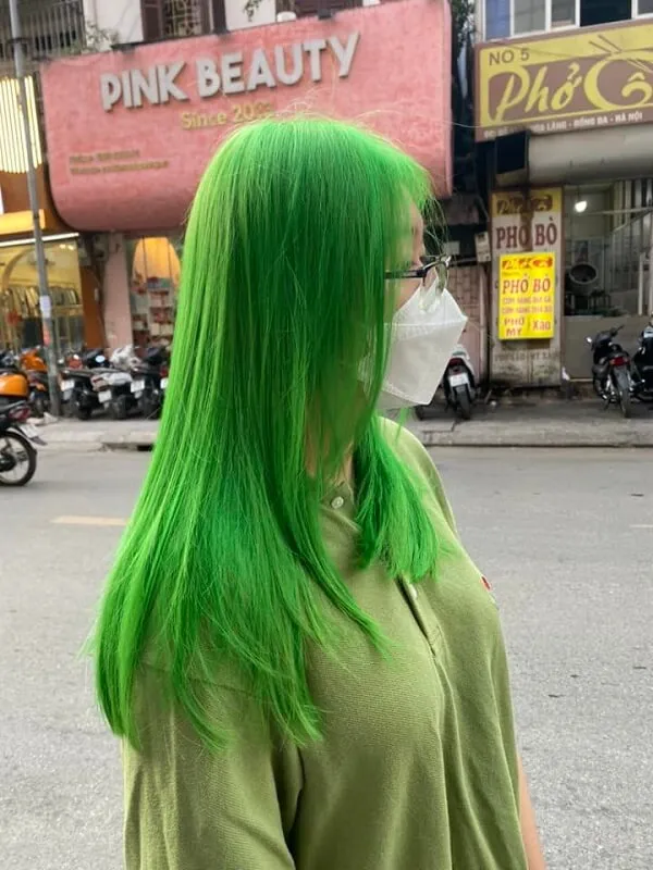 Mẫu tóc ngắn đẹp có một người phụ nữ mái màu xanh lá cây tươi sáng đi xuống phố