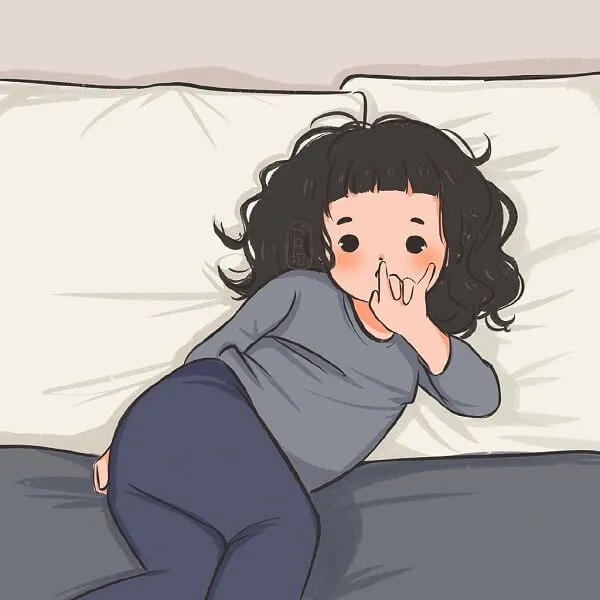 Có một cô bé đang nằm trên giường với chiếc gối