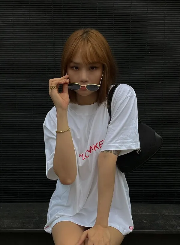 Ảnh miu lê sexy người phụ nữ ngồi trên băng ghế nói chuyện điện thoại di động mặc áo phông trắng