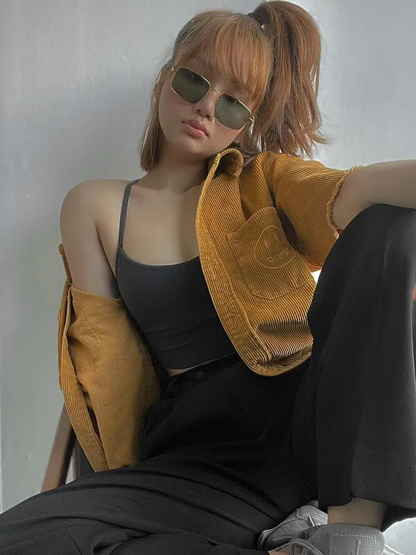 Ảnh miu lê sexy có một người phụ nữ ngồi trên ghế đeo kính râm và áo khoác