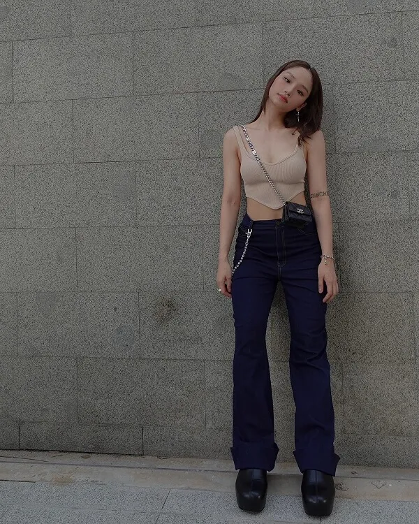 Ảnh sexy của miu lê có một người phụ nữ đứng trước tường với hai tay trên hông