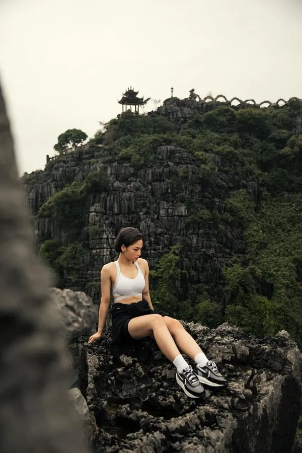 Ảnh sexy miu lê người phụ nữ ngồi trên đỉnh đá trước ngọn núi