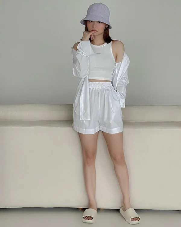 Miu lê sexy có một người phụ nữ đứng trên chiếc ghế dài mặc áo trắng và quần short