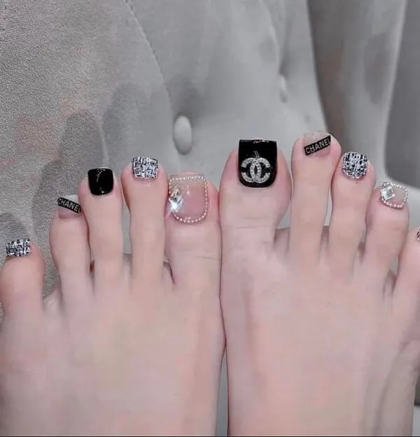 Nail chân có hai cặp móng đen trắng với logo chanel trên chúng