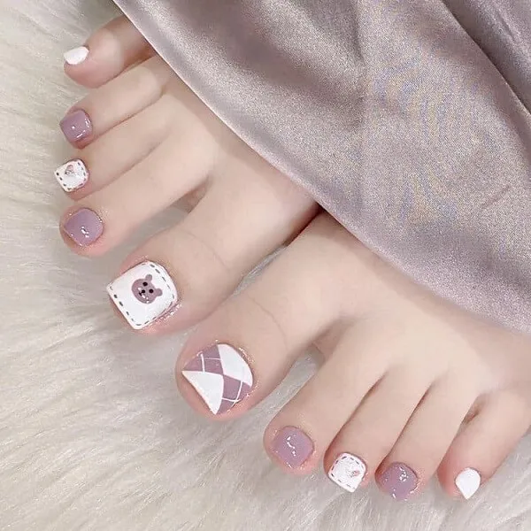 Nail chân cute có đôi của một người phụ nữ với các thiết kế màu hồng và trắng trên chúng