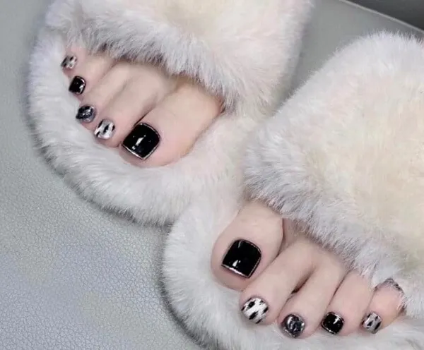 Nail chân có một đôi dép lông với thiết kế màu đen và trắng trên chúng