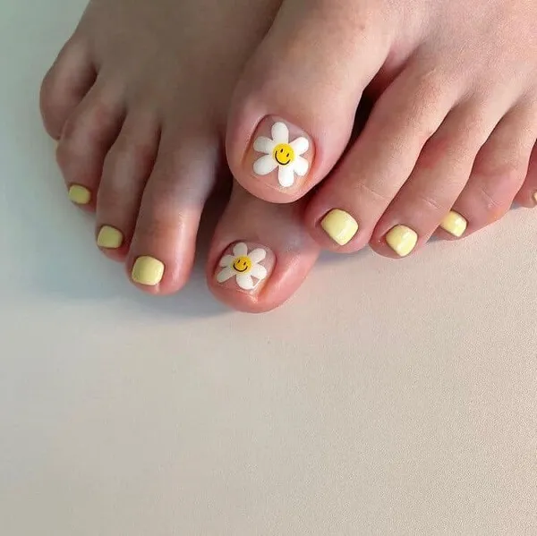 Nail chân vẽ cute có một đôi của người với những bông hoa màu vàng và trắng trên chúng