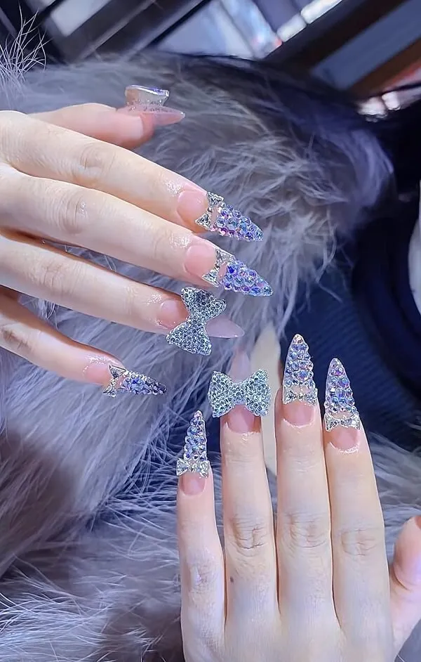 Nail cô dâu màu thạch bàn tay được cắt tỉa cẩn thận của một người phụ nữ có móng dài và chiếc nhẫn trên ngón ấy