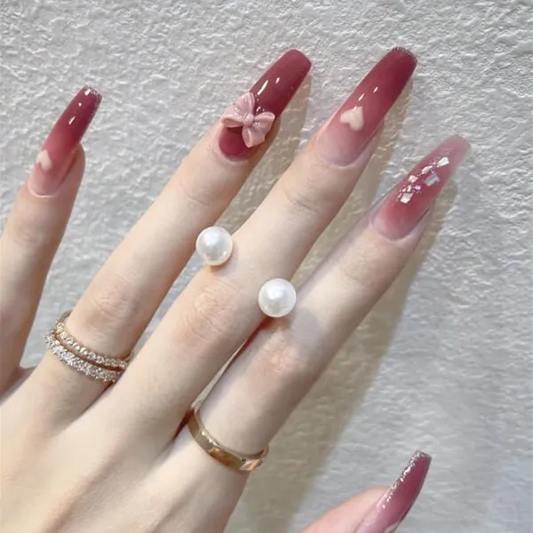Nail cô dâu đây là một cận của bàn tay người với móng màu đỏ và chiếc nhẫn ngọc trai