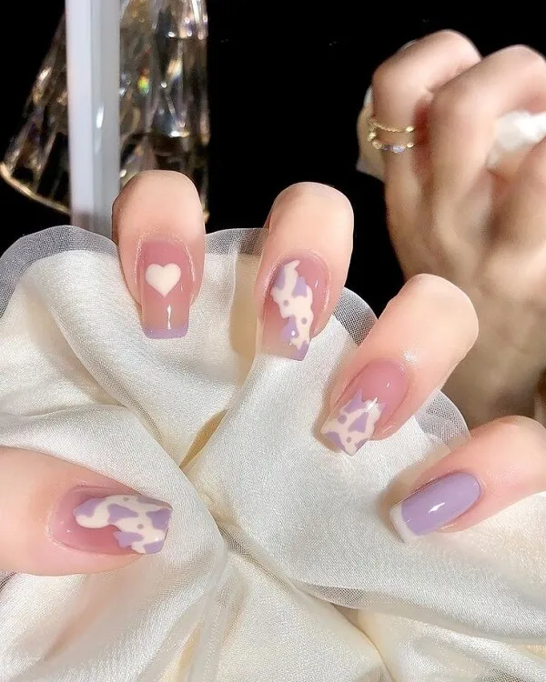 Nail cute đây là hình ảnh bàn tay của một người phụ nữ với móng màu tím và trắng