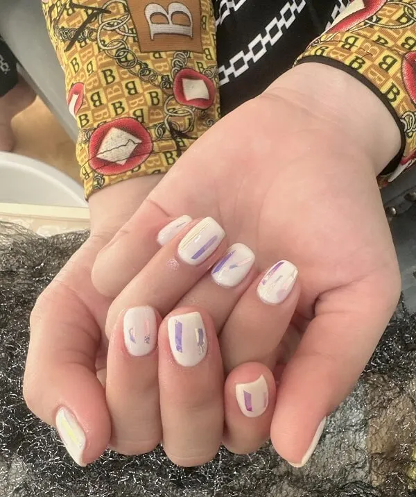 Nail màu trắng gạo đây là một cận của bàn tay người với móng và tím