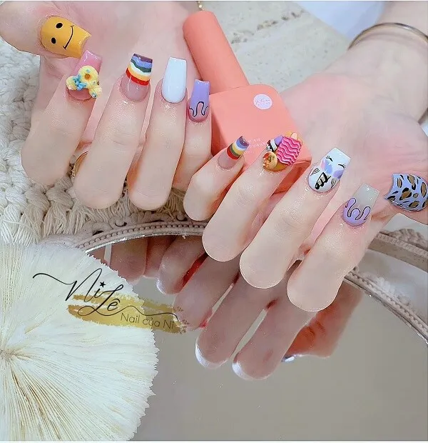 Nail móng ngắn cute có một người cầm điện thoại di động với các thiết kế khác nhau trên đó