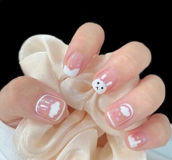 Nail cute ai đó đang cầm một móng tay màu hồng và trắng với thiết kế hello kitty trên