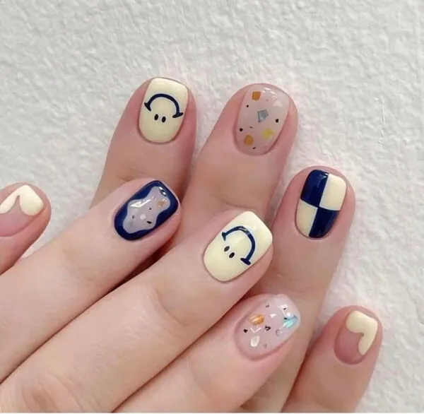 Nail móng ngắn cute có một bàn tay của người phụ nữ với màu trắng và xanh thiết kế gấu trên đó