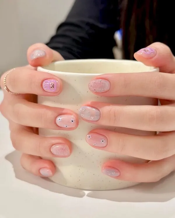 Những mẫu nail đẹp đơn giản có một người phụ nữ cầm cốc cà phê với thiết kế màu hồng và trắng