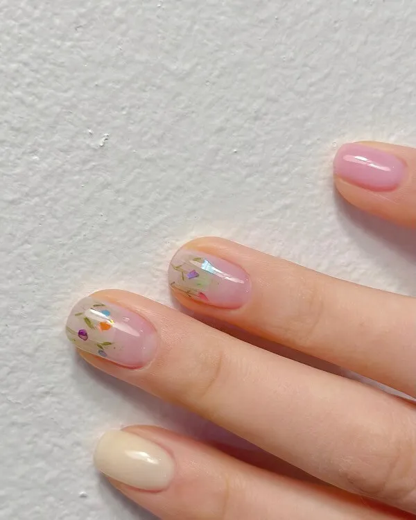 Mẫu nail đơn giản có một bàn tay của người phụ nữ với móng màu hồng và trắng trên đó