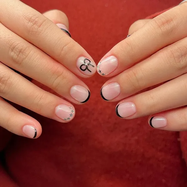 Những mẫu nail đẹp đơn giản có một bàn tay của người với móng màu hồng và đen