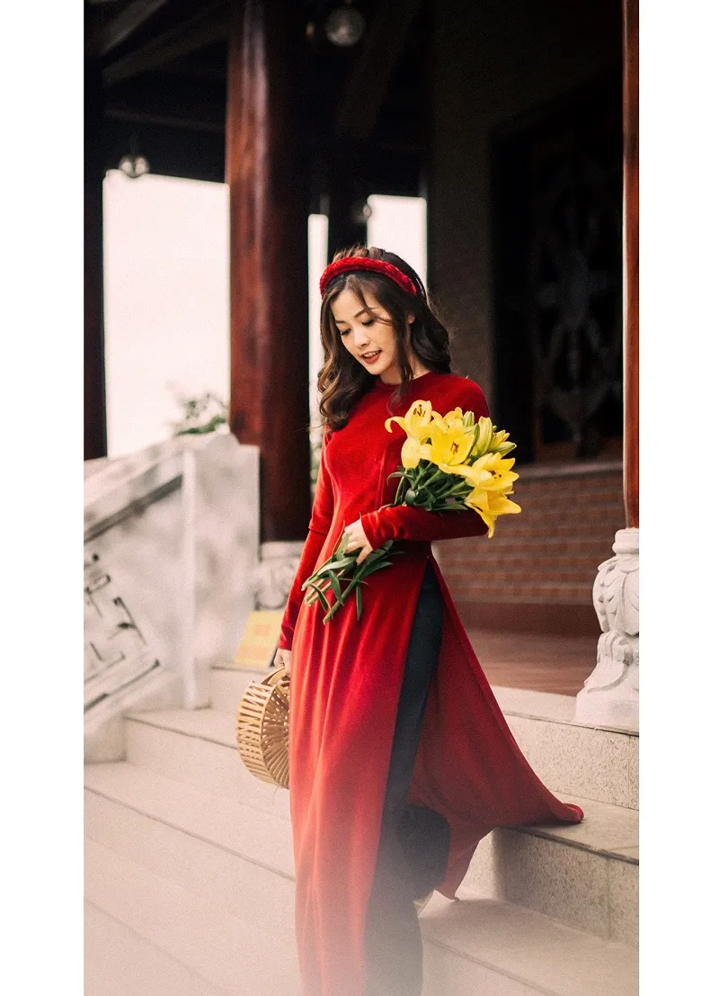 Ảnh chụp tết có một người phụ nữ mặc chiếc váy đỏ dài cầm cái giỏ hoa
