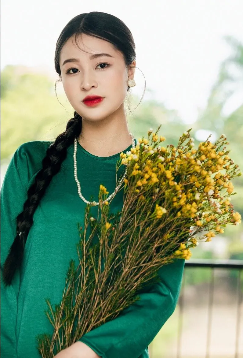 Chụp ảnh tết có một người phụ nữ đang cầm bó hoa
