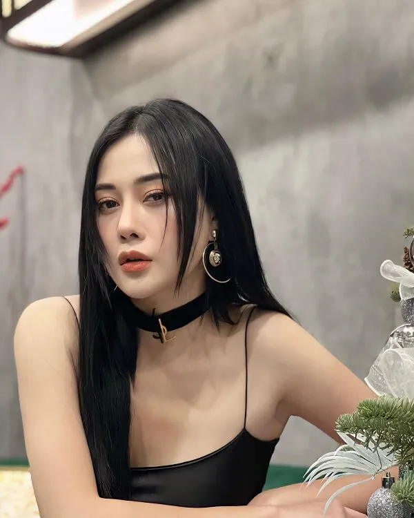 Ảnh của phương oanh có một người phụ nữ ngồi bàn với cái cây trong tay