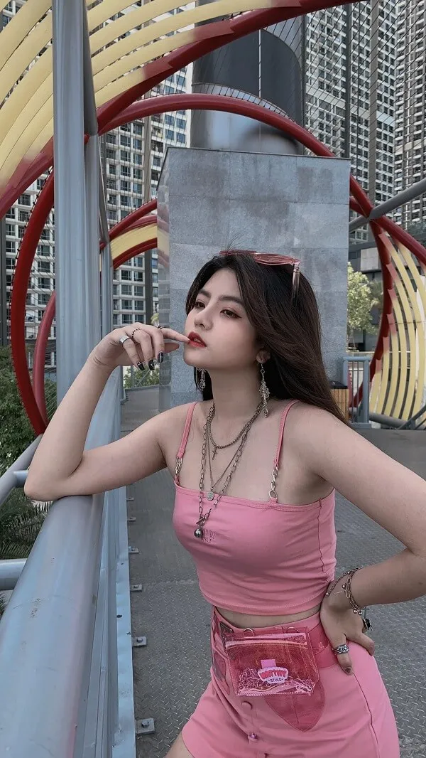 Reency ngô có một người phụ nữ mặc chiếc váy màu hồng tạo dáng cho bức tranh