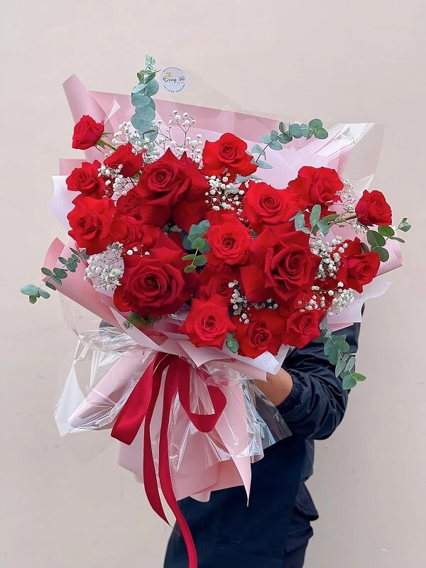 Một người phụ nữ cầm một bó hoa hồng đỏ ảnh hoa valentine