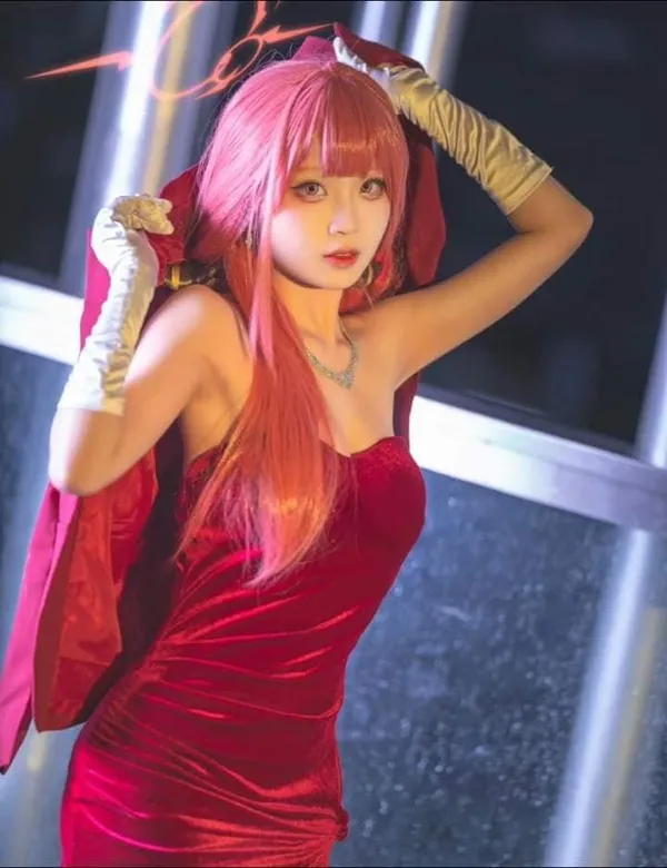Shimoe koharu cosplay có một người phụ nữ mặc chiếc váy đỏ đang tạo dáng với hai tay trên đầu
