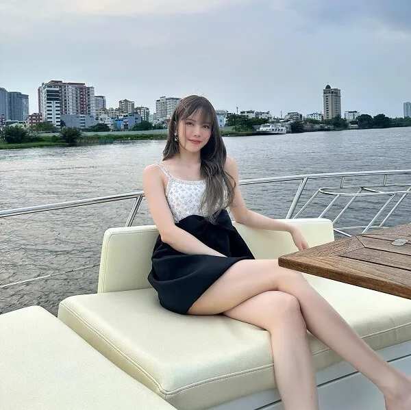 Thiều bảo trâm bikini có một người phụ nữ đang ngồi trên chiếc ghế dài bên mặt nước