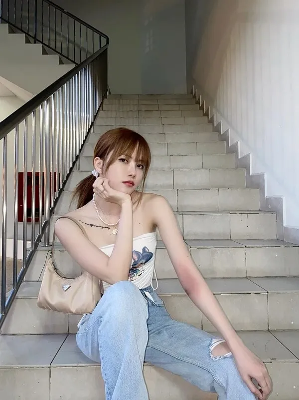 Thiều bảo trâm bikini có một người phụ nữ ngồi trên cầu thang nói chuyện điện thoại di động của cô ấy