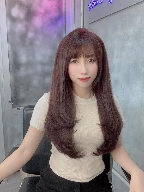 Tóc mullet layer nữ có một người phụ đang ngồi trên ghế với mái dài