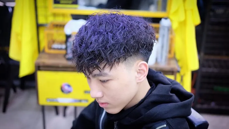 Tóc mohican có một chàng trai trẻ với mohawk màu tím trên đầu