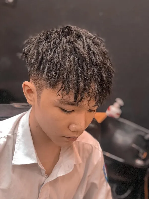 Tóc mohican có một chàng trai trẻ ngồi bàn với đĩa thức ăn