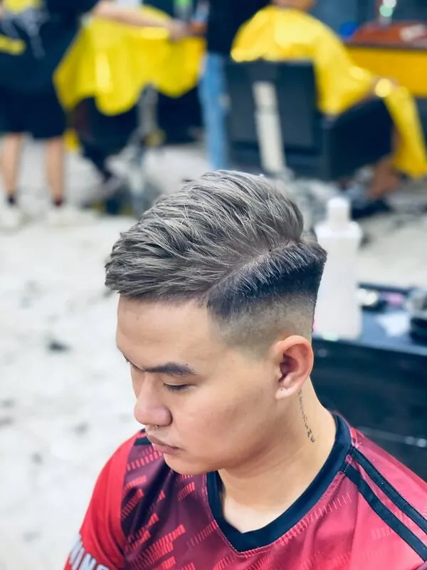 Tóc mohican có một chàng trai trẻ ngồi trong cửa hàng cắt bị