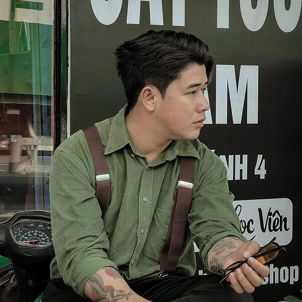 Tóc nam side part có một người đàn ông ngồi trên xe máy hình xăm tay