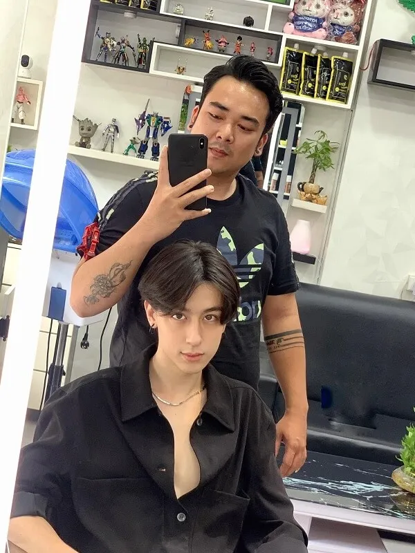 Kiểu tóc nam side part có một người đàn ông đang bị cắt bởi phụ nữ