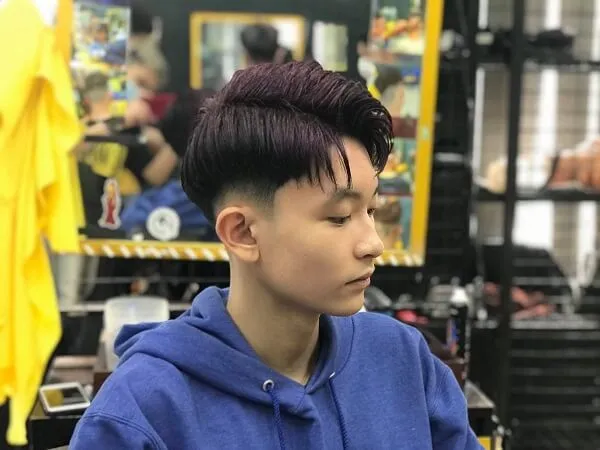 Tóc nam side part ngắn có một cậu bé ngồi bàn với đĩa thức ăn