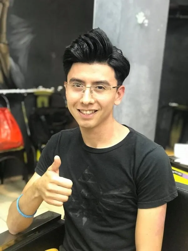 Tóc nam side part ngắn có một chàng trai trẻ ngồi bàn đưa ra ngón tay cái