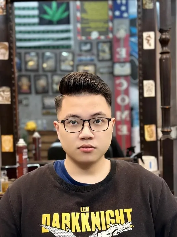 Tóc nam undercut có một chàng trai trẻ với kính đứng trong cửa hàng cắt