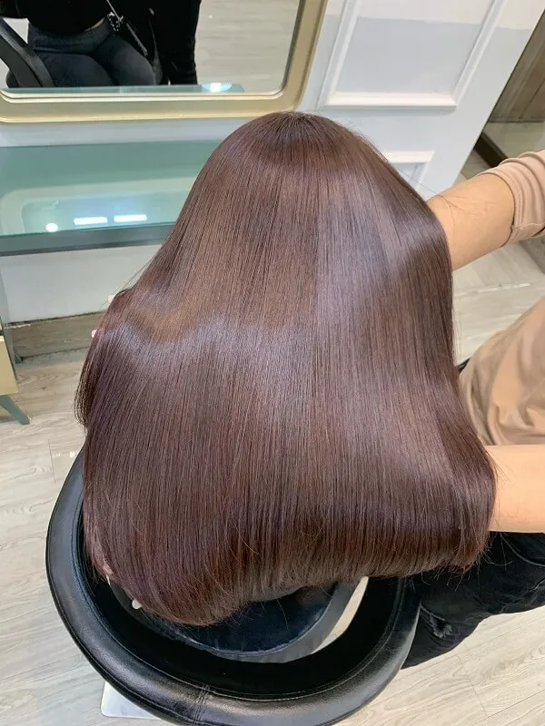 Tóc ngắn duỗi thẳng có một người phụ nữ mái nâu dài ngồi trên ghế