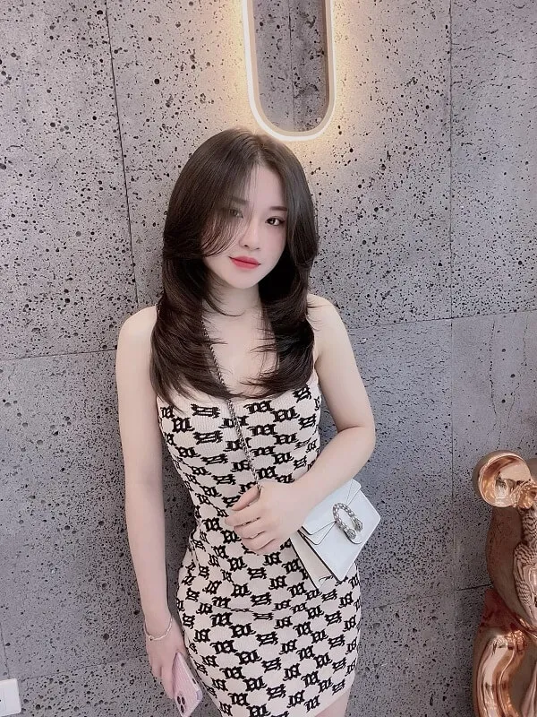 Tóc ngắn ngang vai duỗi thẳng có một người phụ nữ đang tạo dáng cho bức tranh trong chiếc váy