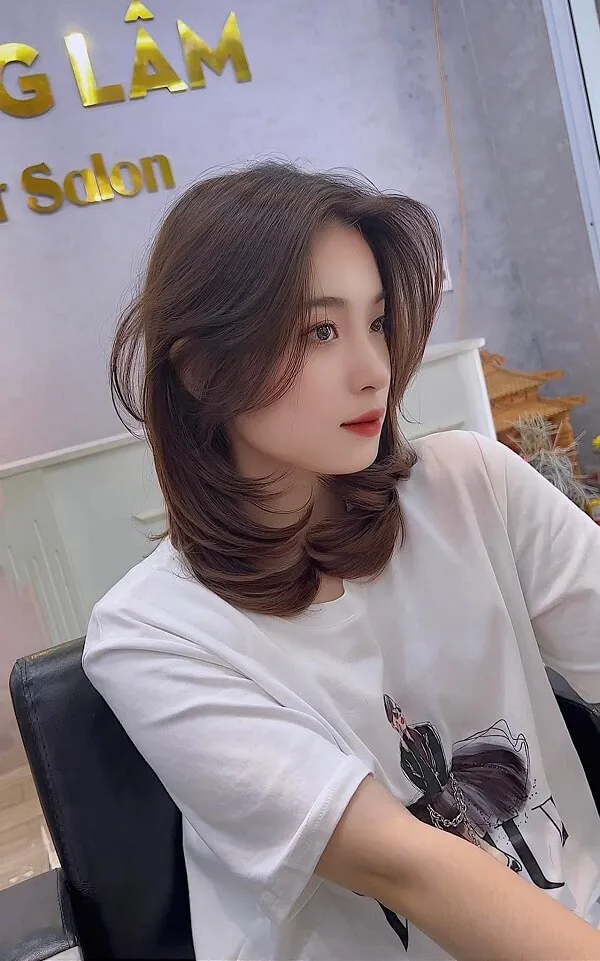 Tóc ngang lưng uốn đuôi chữ có một người phụ nữ ngồi bàn với ly rượu